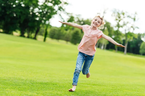 Счастливая девочка бежит в парке — стоковое фото