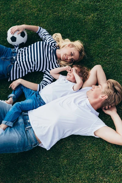 Parents avec fils reposant sur l'herbe — Photo de stock