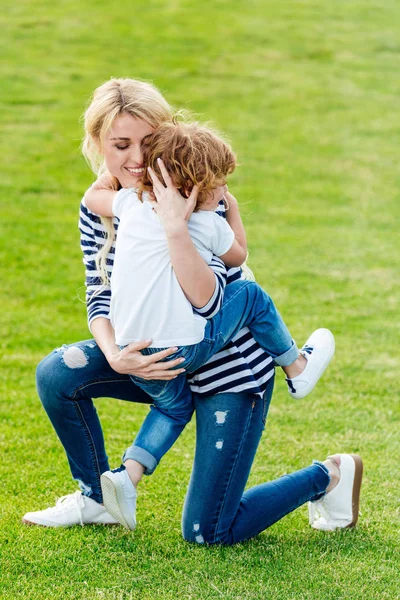 Madre feliz con su hijo en el parque - foto de stock