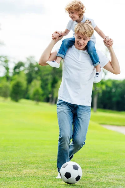 Father and son playing soccer in park — Stock Photo