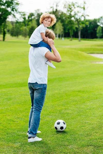 Pai e filho jogando futebol no parque — Fotografia de Stock