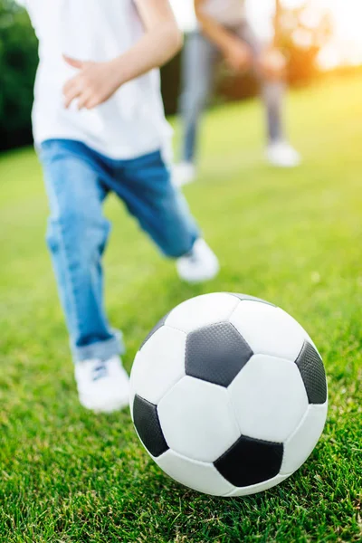 Junge spielt Fußball im Park — Stockfoto