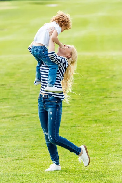 Madre feliz con su hijo en el parque - foto de stock