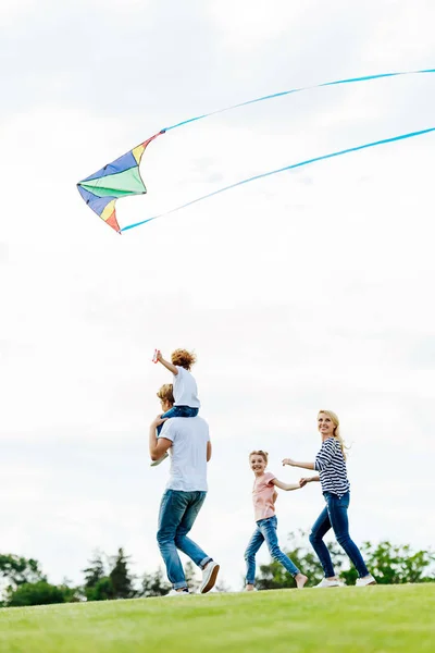 Famiglia che gioca con aquilone al parco — Foto stock