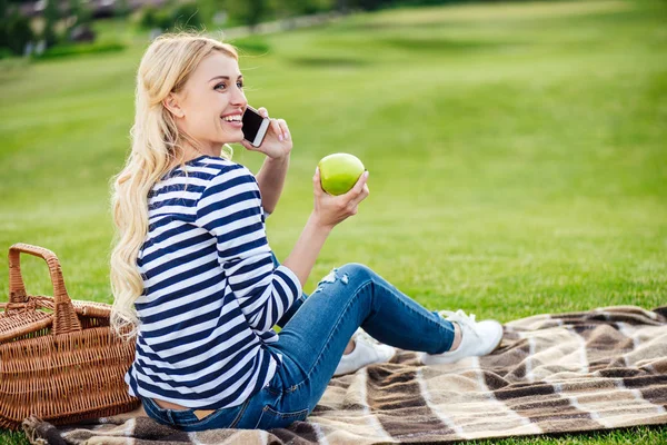 Woman talking on smartphone at picnic — Stock Photo