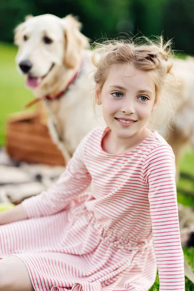 Fille heureuse avec chien au pique-nique — Photo de stock