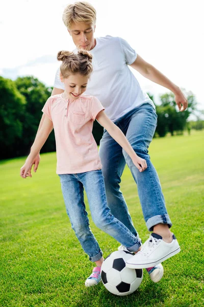 Батько і дочка грають у футбол у парку — стокове фото