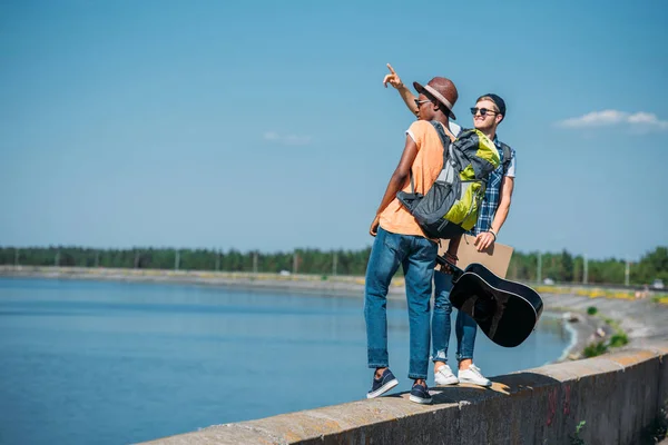 Multicultural men with cardboard hitchhiking — Stock Photo