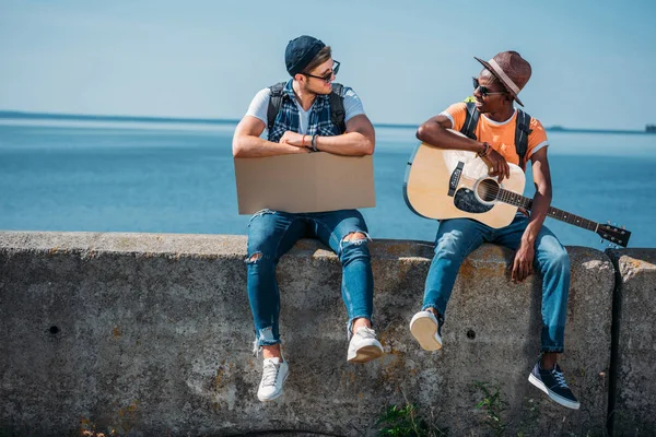 Multicultural hitchhikers with cardboard — Stock Photo