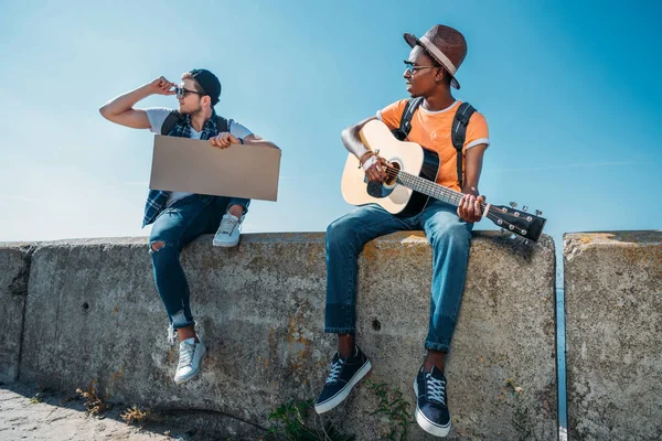 Multicultural hitchhikers with cardboard — Stock Photo