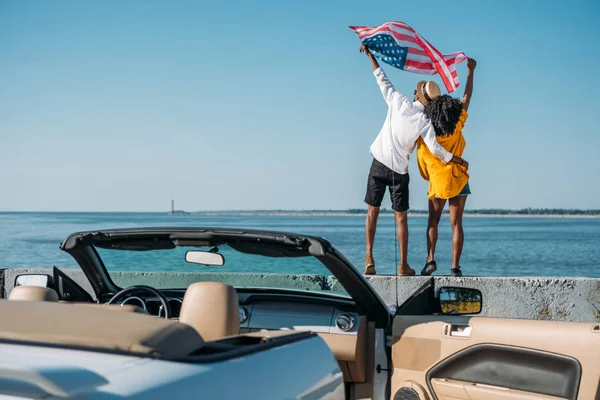 Pareja afroamericana con bandera americana - foto de stock