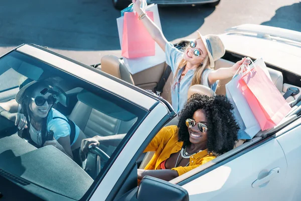 Mujeres multiétnicas en coche después de ir de compras - foto de stock