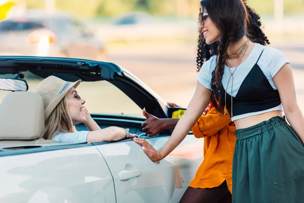 Mujeres multiétnicas cerca de coche - foto de stock