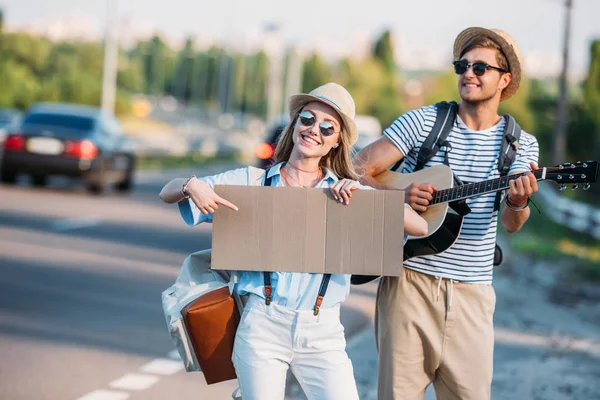 Couple hitchhiking together — Stock Photo