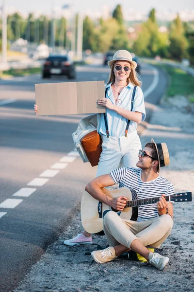 Couple hitchhiking together — Stock Photo