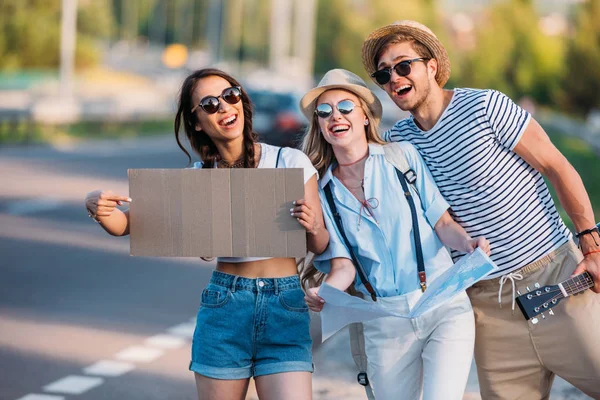 Amigos multiculturales haciendo autostop juntos - foto de stock