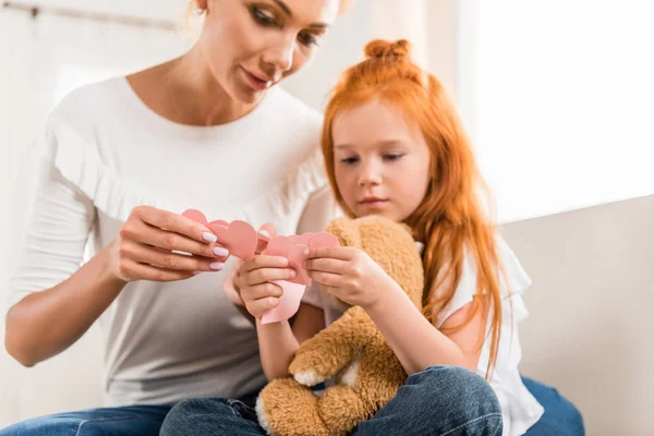 Madre e hija con corazones de papel - foto de stock