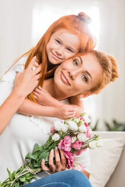 Madre feliz con flores e hija - foto de stock