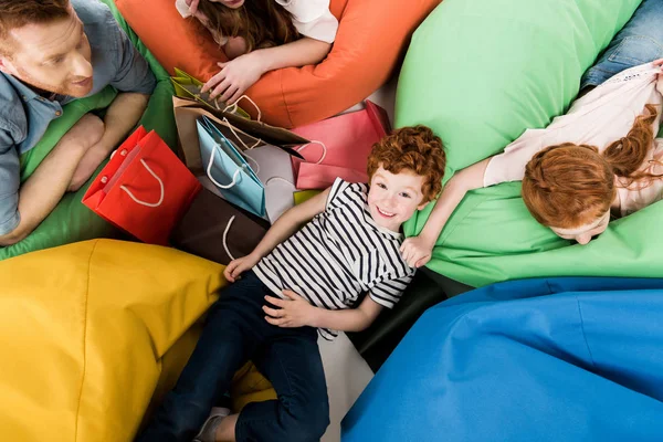 Familia en sillas bolsa de frijol después de ir de compras - foto de stock