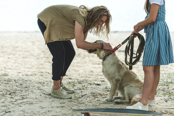 Пара с собакой на пляже — стоковое фото