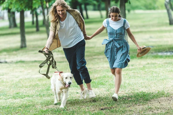 Casal correndo com cão — Fotografia de Stock