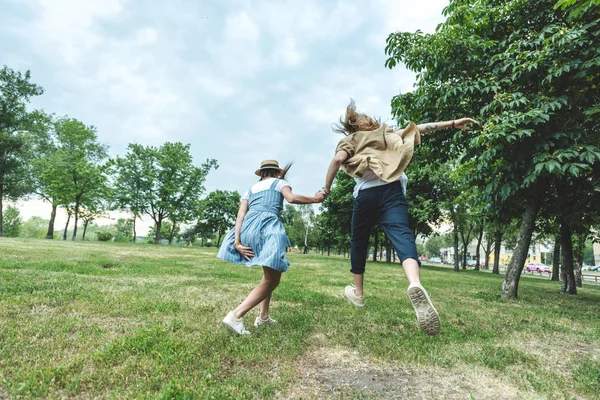 Jeune couple courant à travers le champ — Photo de stock