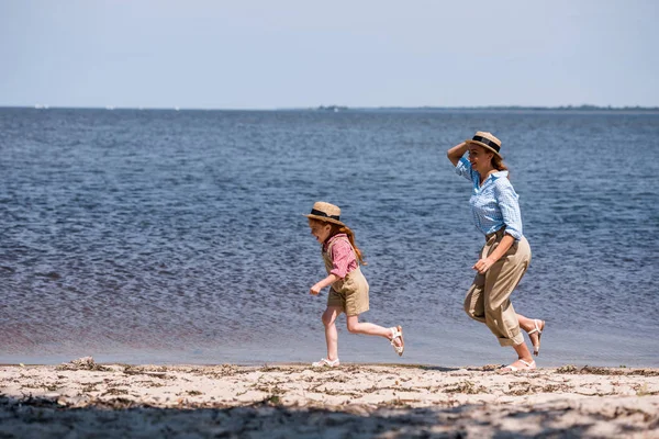 Madre e hija en la orilla del mar - foto de stock