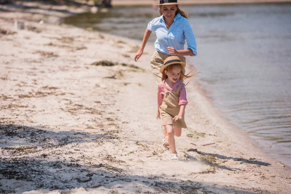 Mutter und Tochter rennen am Strand — Stockfoto
