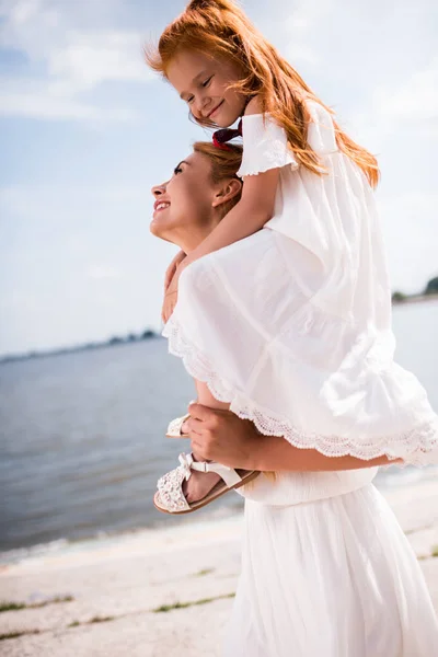 Mother carrying daughter — Stock Photo