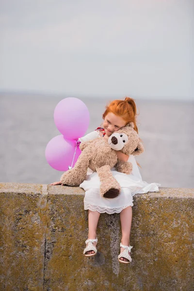 Ребенок с плюшевым мишкой и воздушными шарами — стоковое фото