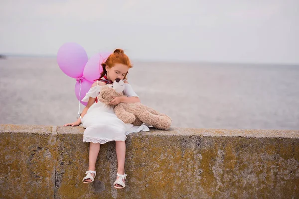 Дитина з плюшевим ведмедем і повітряними кулями — стокове фото