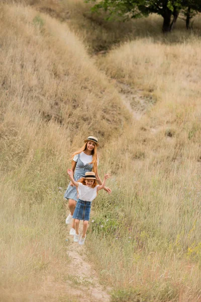 Madre e hija caminando en la colina - foto de stock