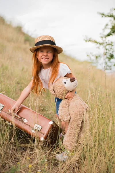 Niño con maleta y osito de peluche - foto de stock