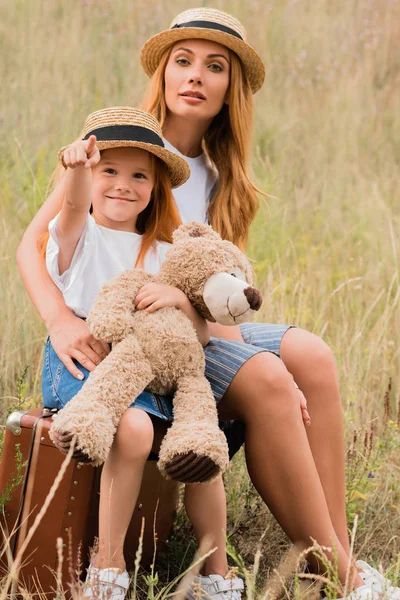 Мати і дочка з валізою і плюшевим ведмедем — Stock Photo