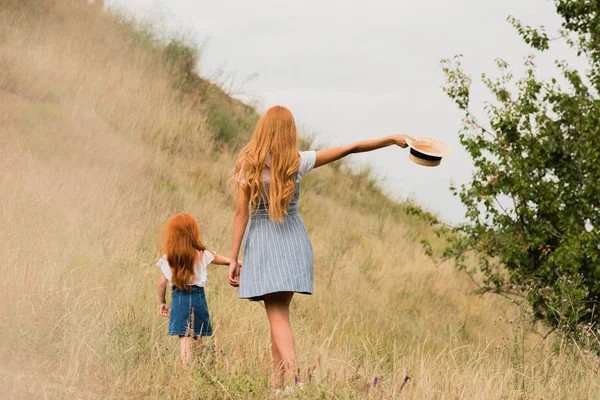Мать и дочь ходят по траве — стоковое фото
