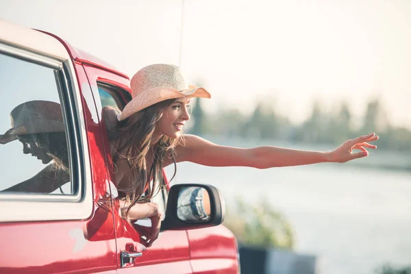 Femme agitant par la fenêtre de la voiture — Photo de stock