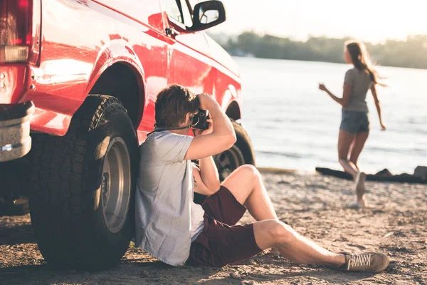 Homme prenant des photos de petite amie sur la plage — Photo de stock