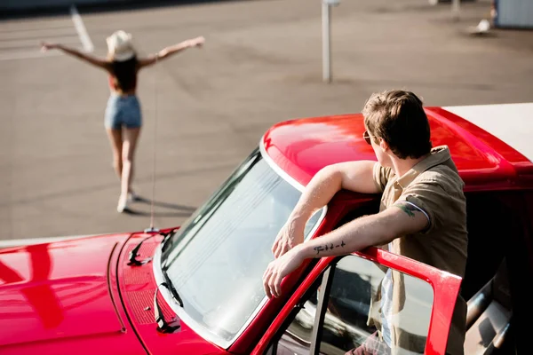 Man in car looking at woman — Stock Photo