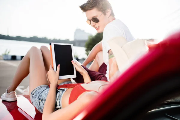 Pareja con tableta digital en el coche — Stock Photo