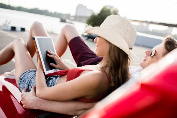 Couple avec tablette numérique sur la voiture — Photo de stock