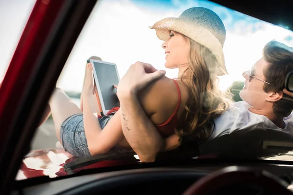 Пара с цифровым планшетом на машине — стоковое фото