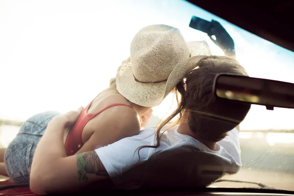 Jovem casal deitado no carro — Fotografia de Stock