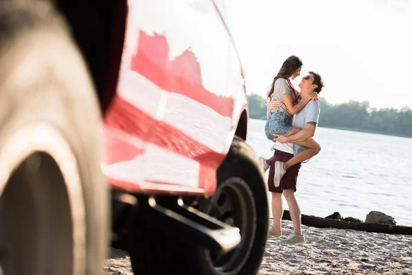 Coche y pareja en la playa - foto de stock