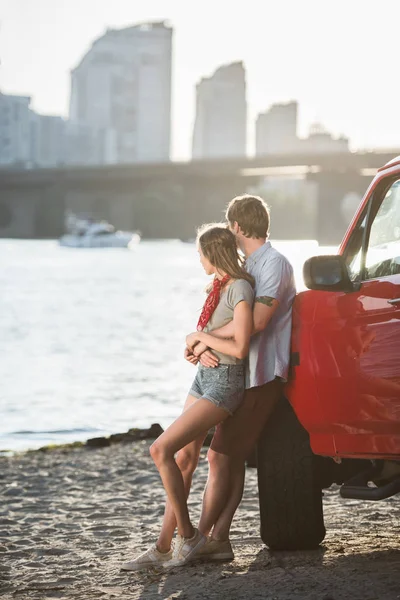 Jeune couple câlin près de la voiture — Photo de stock