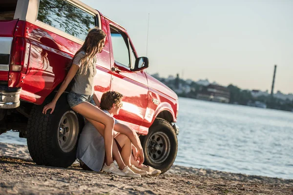 Paar mit Auto am Ufer — Stockfoto
