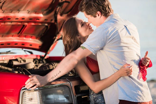 Couple étreignant près de la voiture — Photo de stock