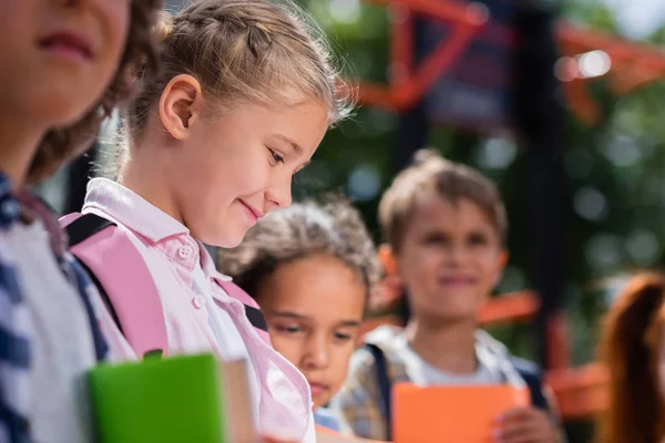 Bambini con libri sul parco giochi — Foto stock