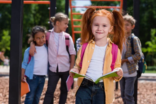 Bambino con libro sul parco giochi — Foto stock