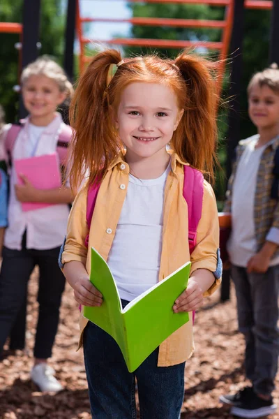 Bambino con libro sul parco giochi — Foto stock