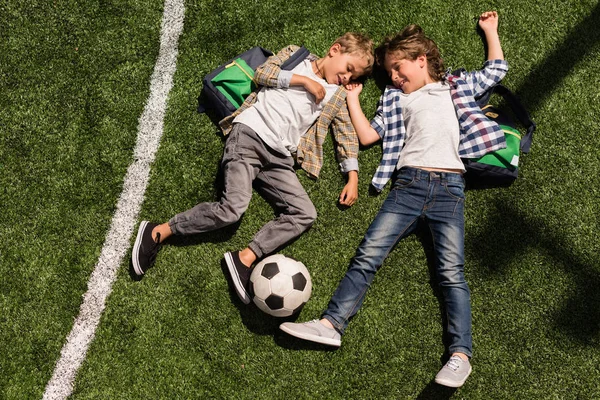 Школярі з футбольним м'ячем — стокове фото